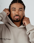 Front view of Brklyn Park grey fleece hoodie worn by male model, featuring relaxed fit and minimalist chest logo