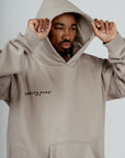 Male model wearing Brklyn Park Essence Fleece Hoodie in gray, heavyweight cotton hoodie with front pocket and tonal logo