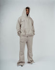 Male model wearing Brklyn Park gray fleece sweatpants with matching hoodie, styled for relaxed supreme streetwear look