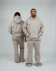 Unisex models wearing Brklyn Park Essence Fleece Sweat Sets featuring gray heavyweight sweatpants and hoodies in minimalist style