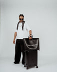 Model wearing the Brklyn Park Archangel Tee white oversized graphic t-shirt with angel artwork and red rose detailing, and leather tote black