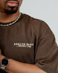 Close-up of Brklyn Park Members Only Tee – brown oversized cotton t-shirt with minimalist white logo on chest
