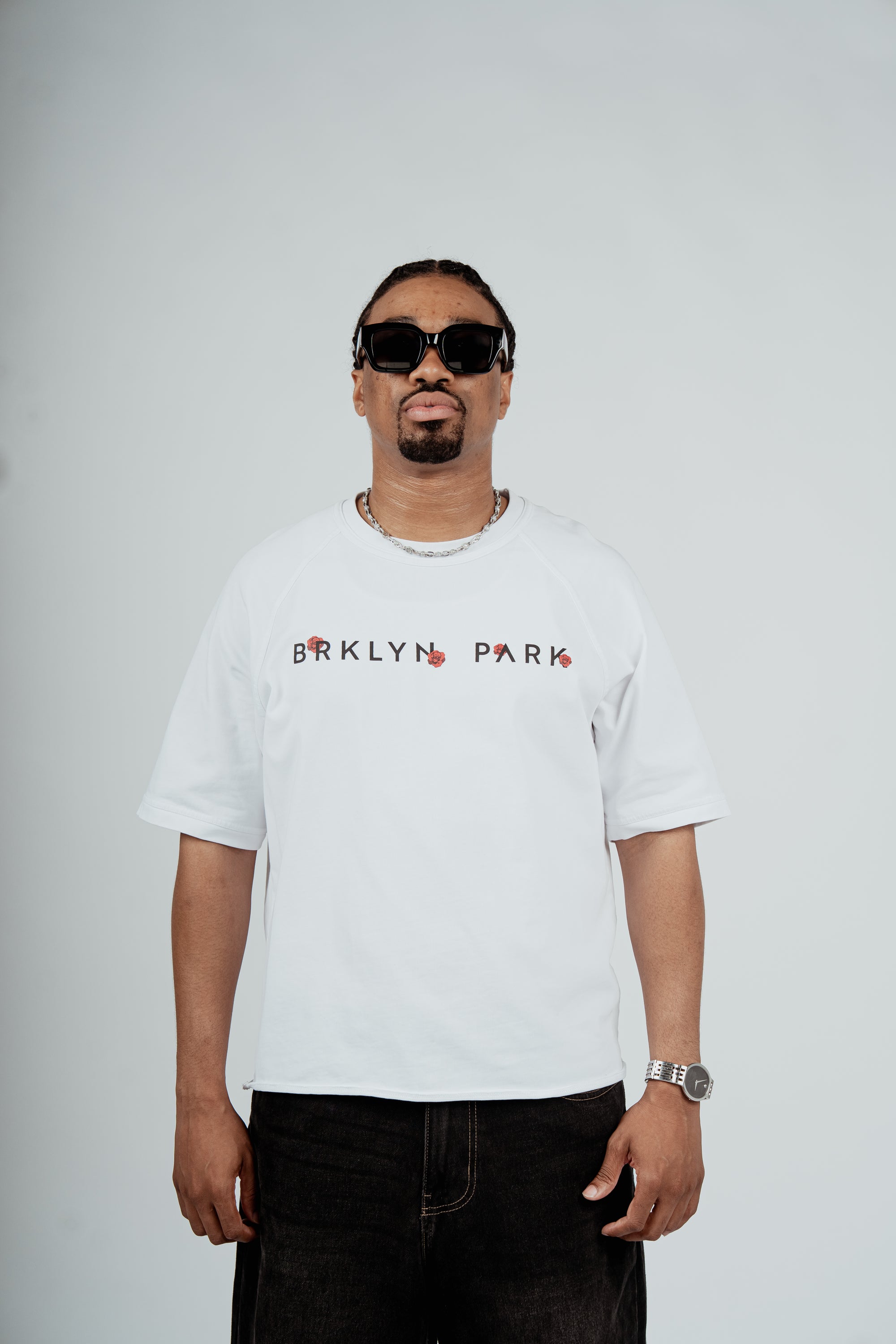 Model wearing the Brklyn Park Archangel Tee white oversized graphic t-shirt with angel artwork and red rose detailing, viewed from the front supreme streetwear