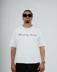 Model wearing the Brklyn Park Archangel Tee white oversized graphic t-shirt with angel artwork and red rose detailing, viewed from the front supreme streetwear