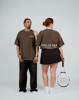 Back view of two models wearing Brklyn Park brown oversized Members Only t-shirts with large graphic text