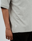 Close-up of side seam on gray Brklyn Park Sanchez Tee showing fabric texture and subtle logo detailing