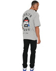 Model walking in Brklyn Park Sanchez Tee showing back graphic artwork and relaxed streetwear fit